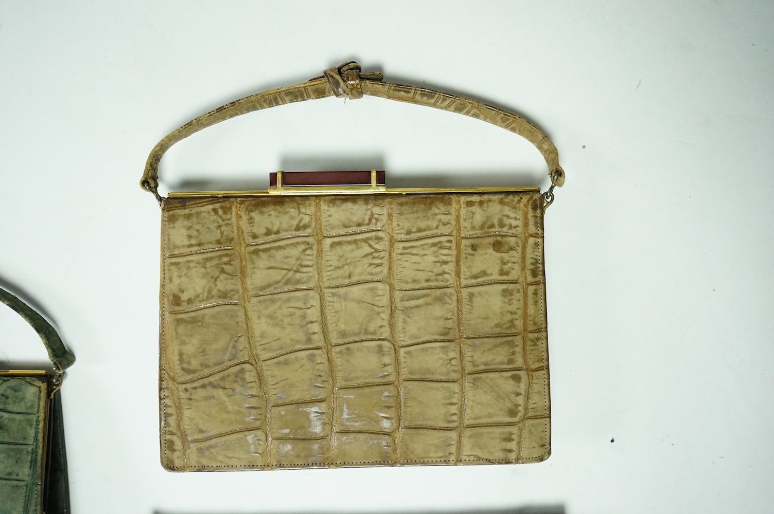 Three stylish Art Deco ladies handbags. A black crocodile clutch bag with an MMW monogram and silver mounted edge and two smaller handbags, one green the other brown, both faux crocodile with stylish bakelite clasps. Clu